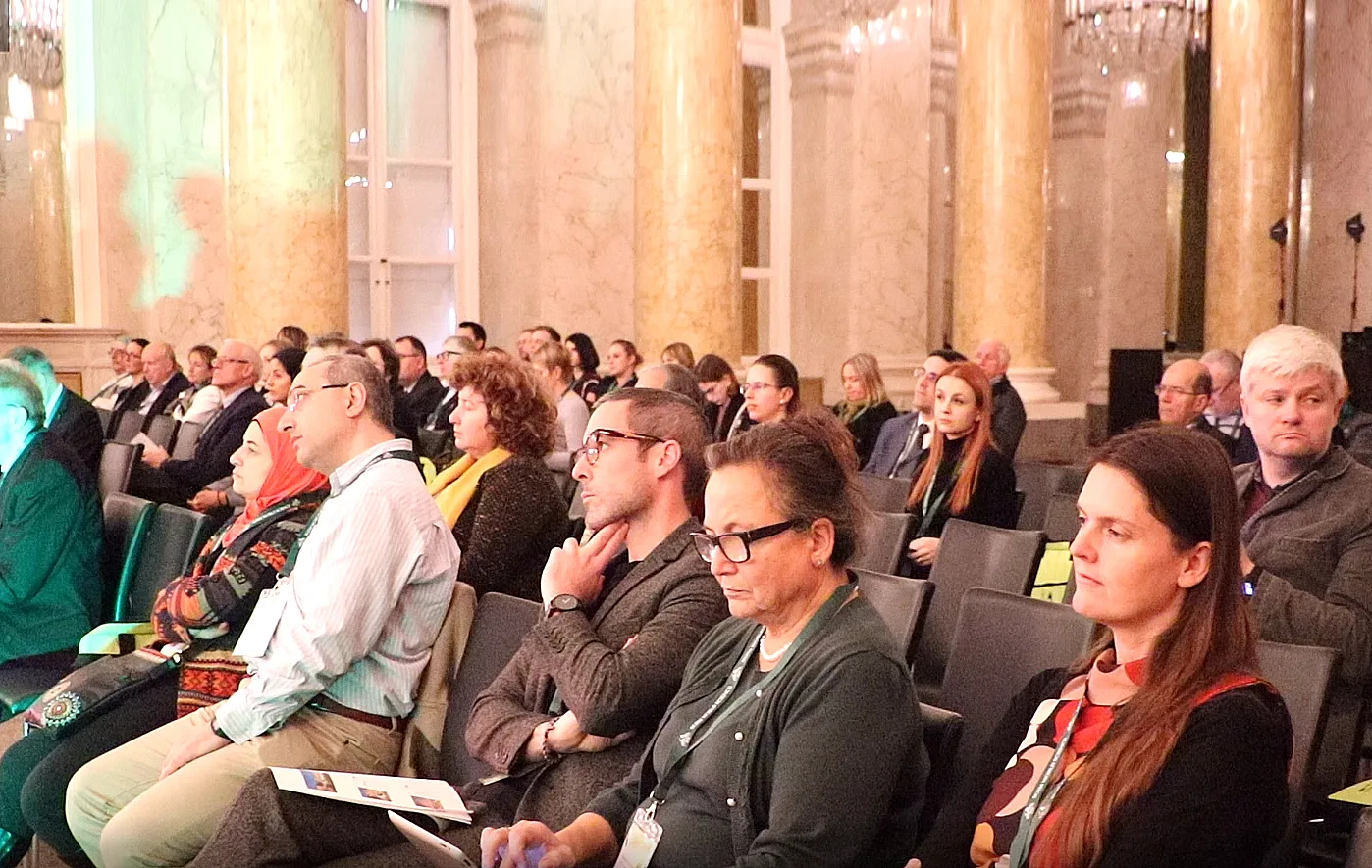 Conference audience seated in an ornate hall