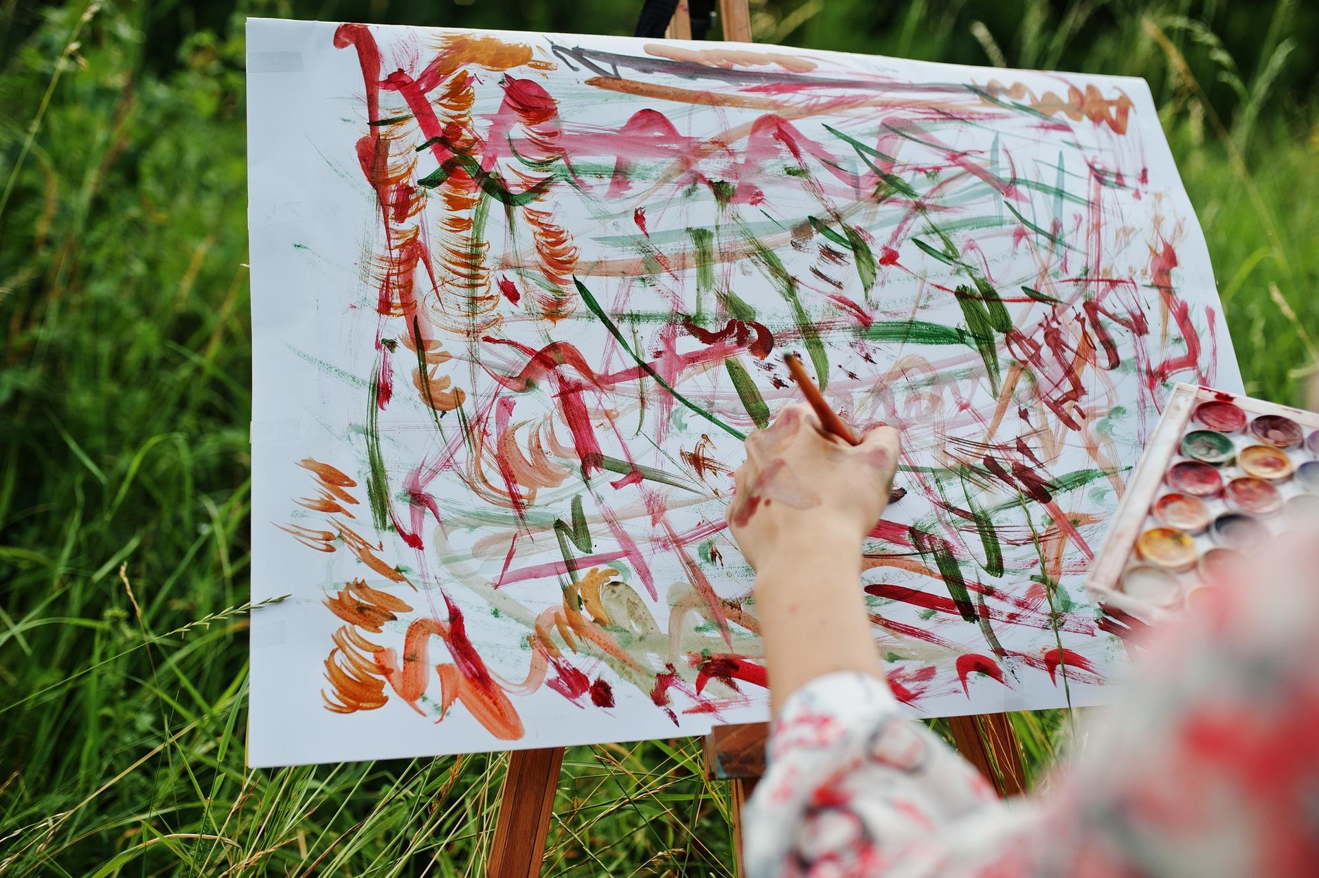 An artist making a colourful painting outdoors