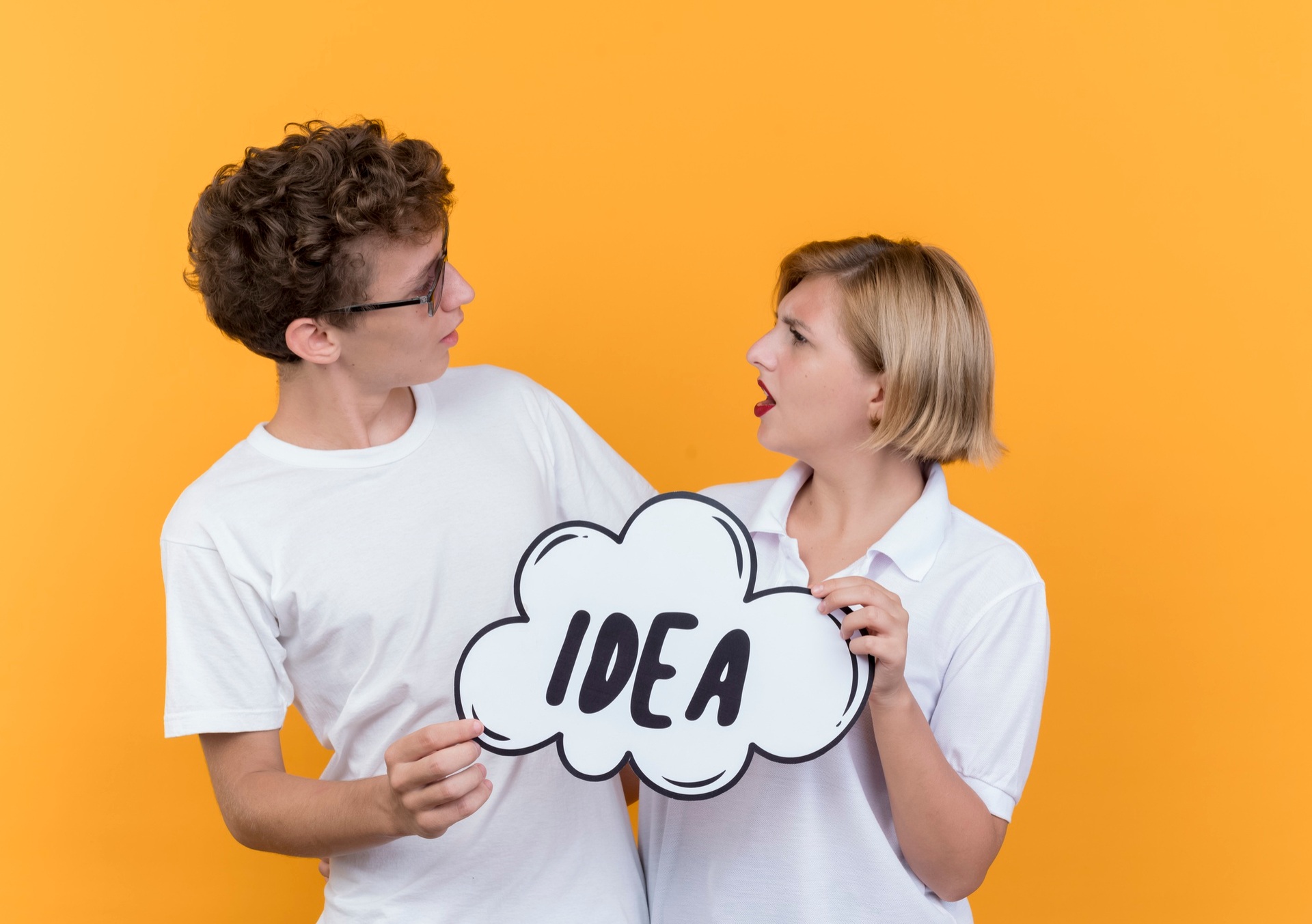 Two people holding a speech bubble labelled Idea