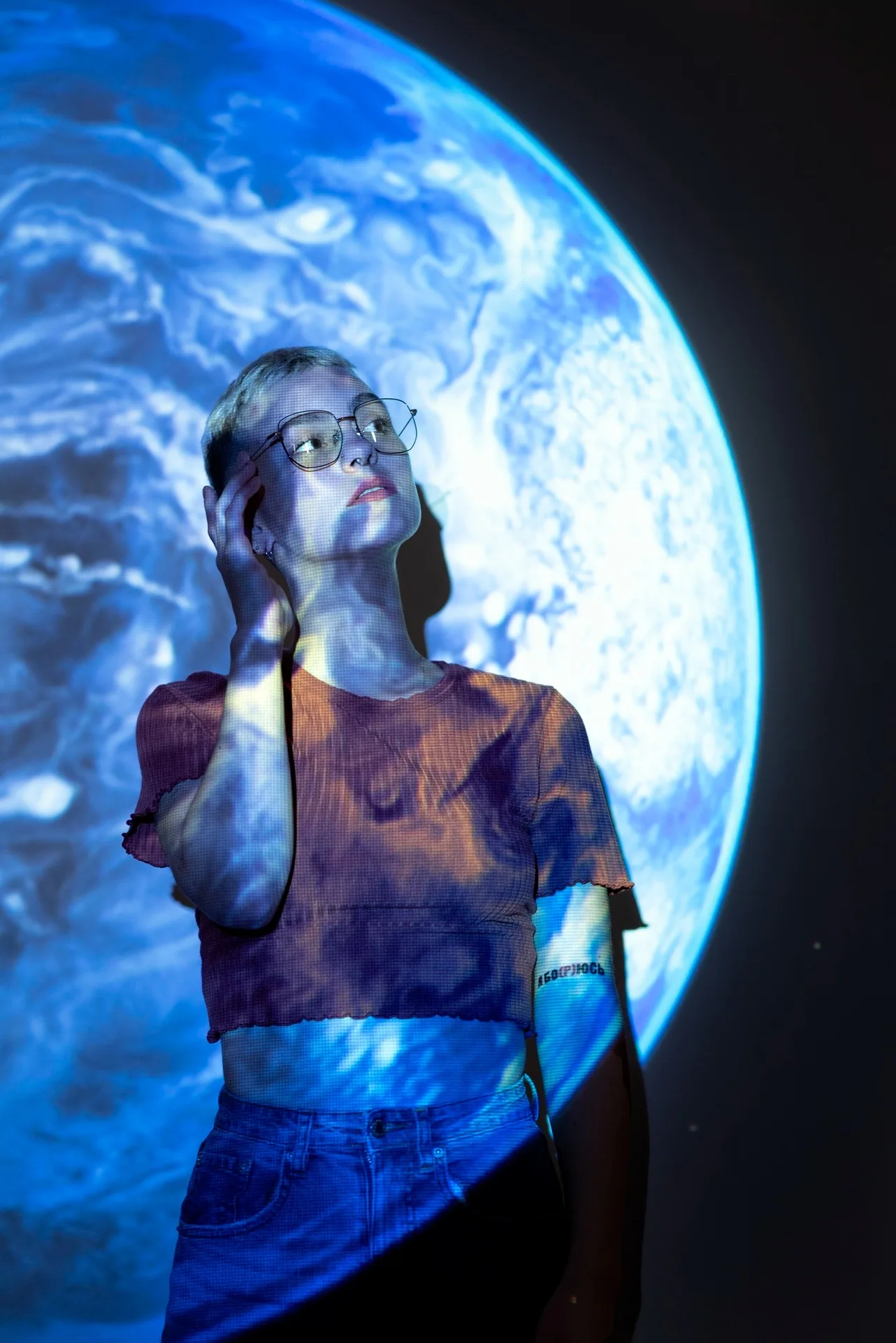 A visitor beside a large illuminated view of Earth