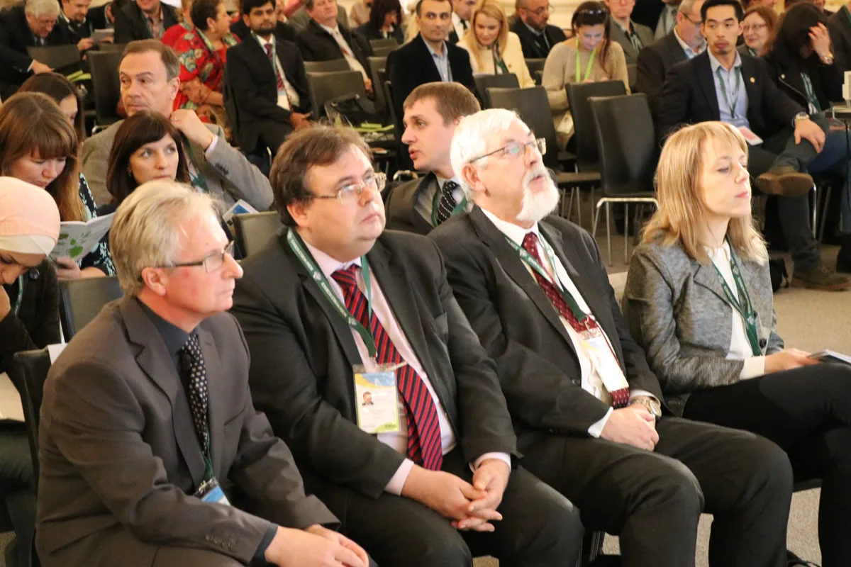 Conference delegates seated in the front rows of an auditorium