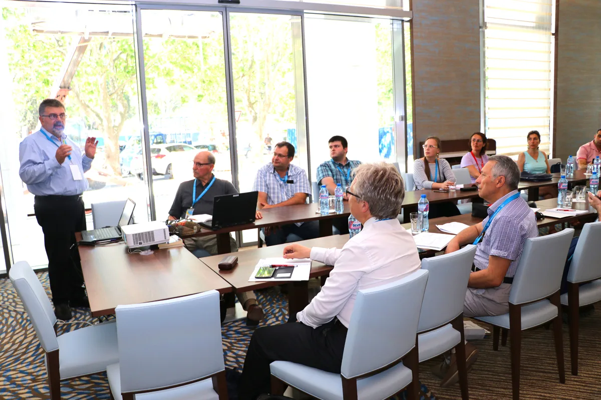 A researcher presenting to colleagues around a meeting table