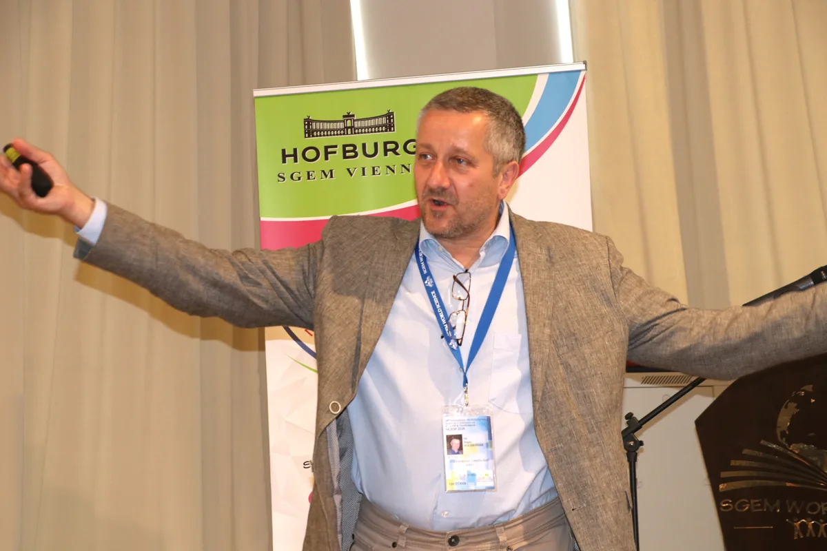 An SGEM speaker addressing the audience with outstretched arms