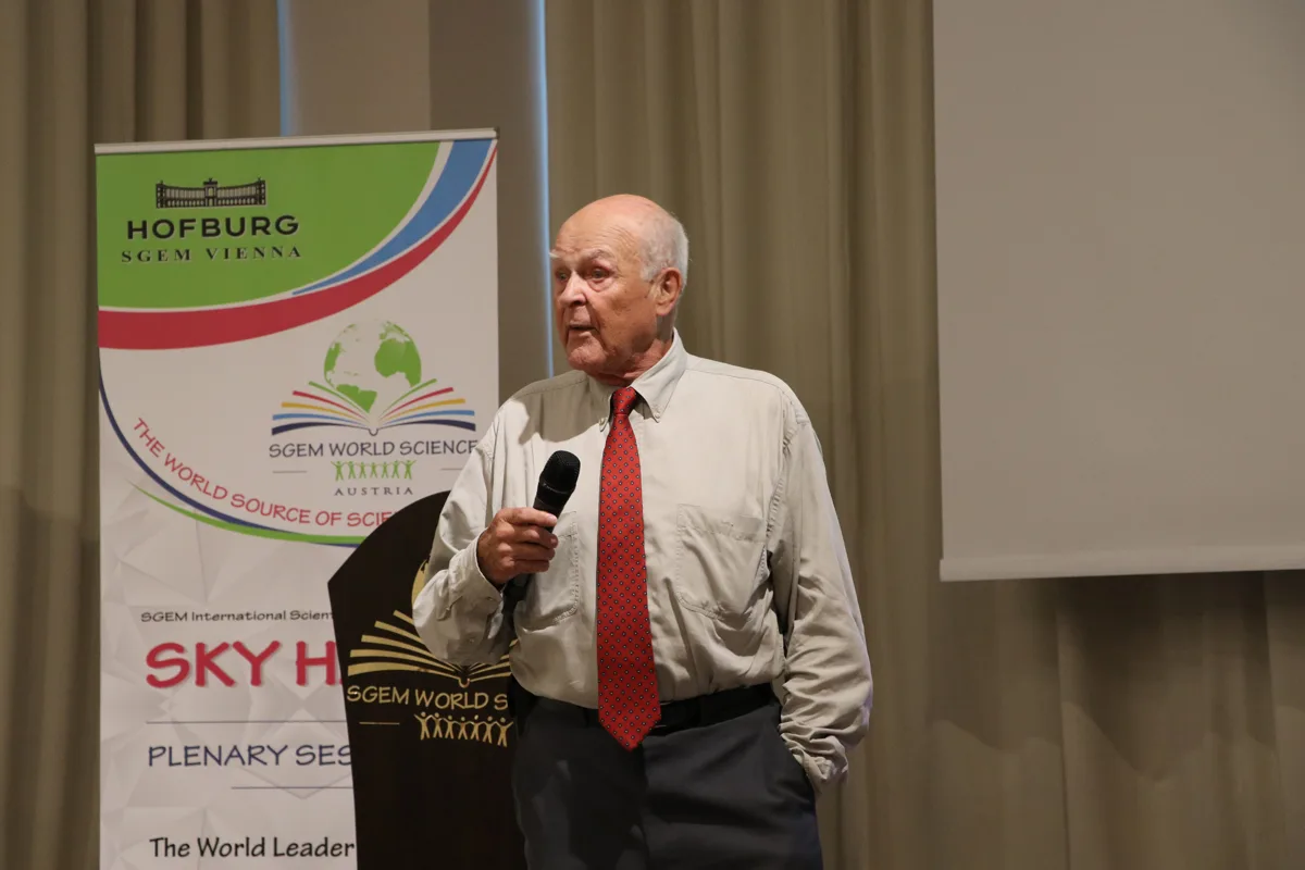 A scientist holding a microphone beside the SGEM lectern