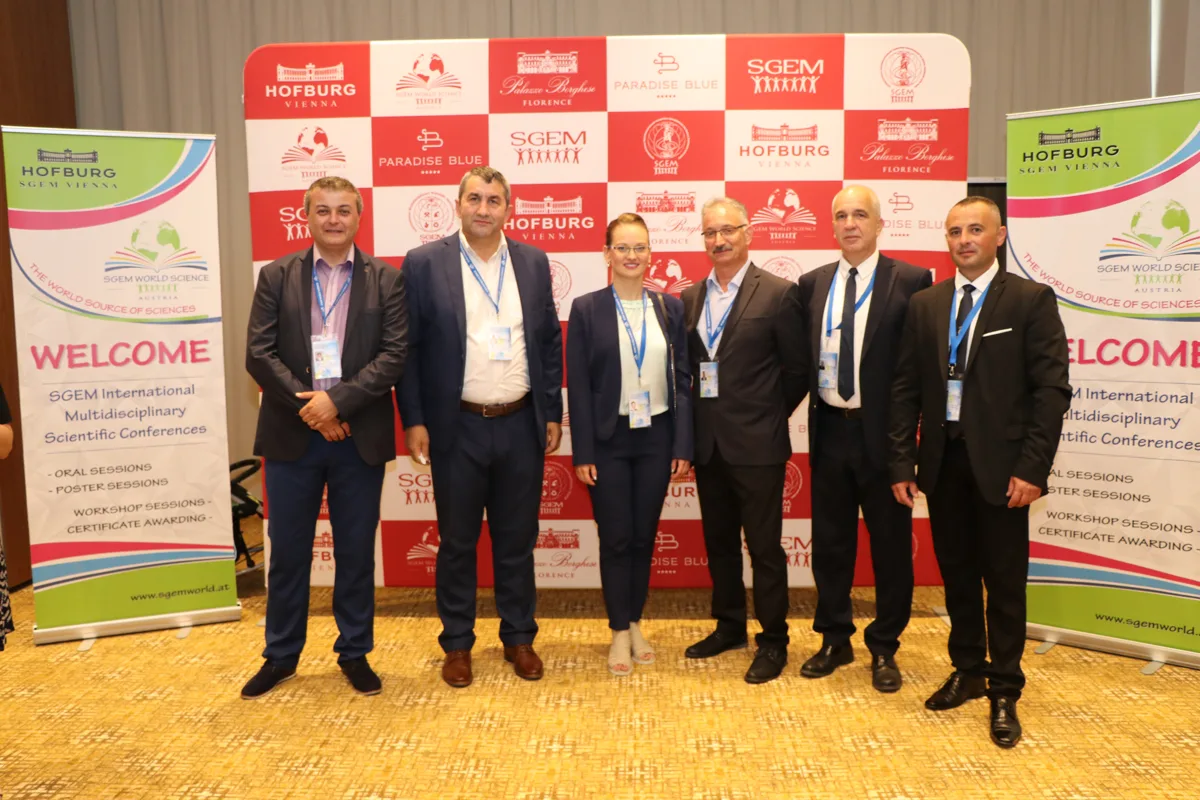 Six SGEM delegates posing in front of conference banners