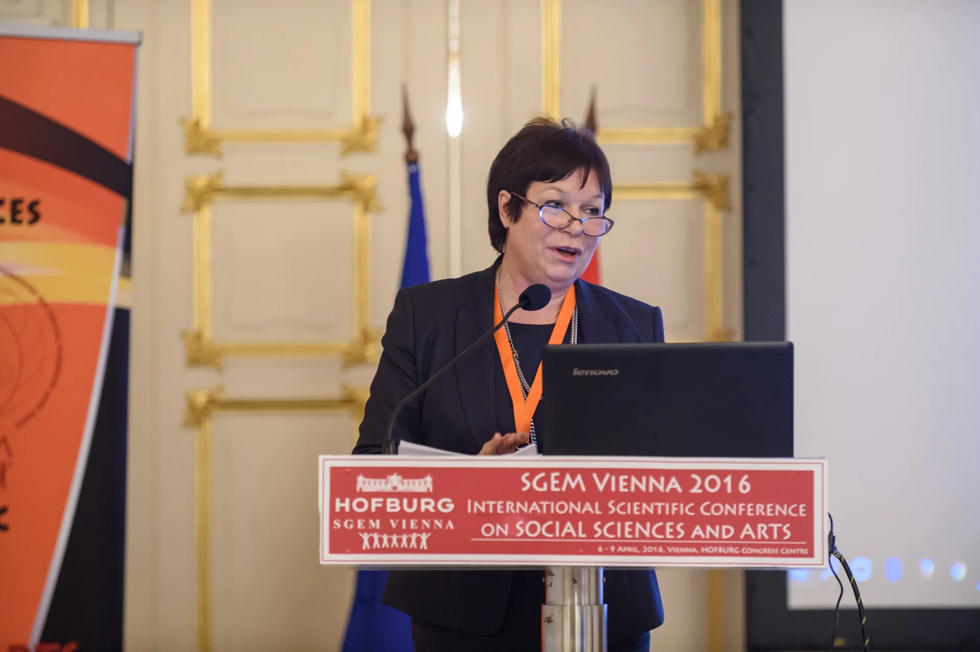 An SGEM Vienna presenter reading from a laptop at the lectern