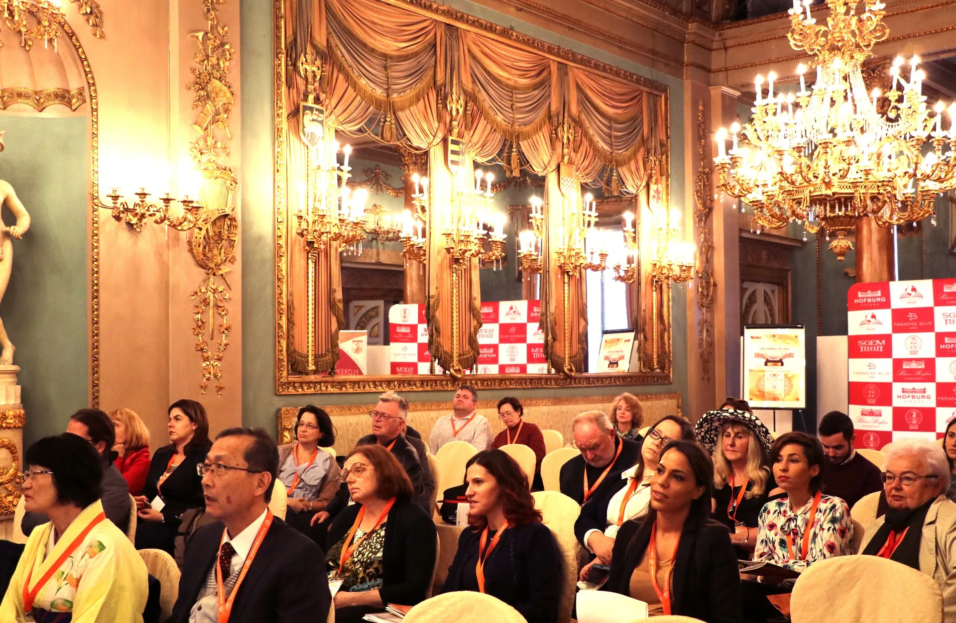 An attentive conference audience in an ornate Florentine hall