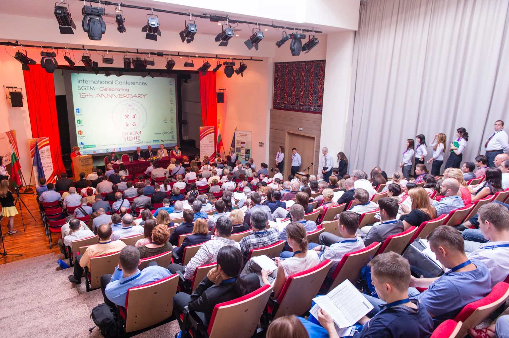 A full scientific conference auditorium viewed from the back