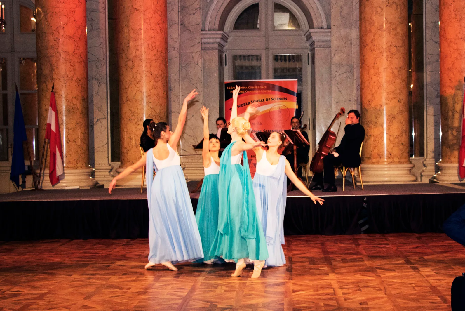 Dancers in flowing dresses performing before a chamber ensemble