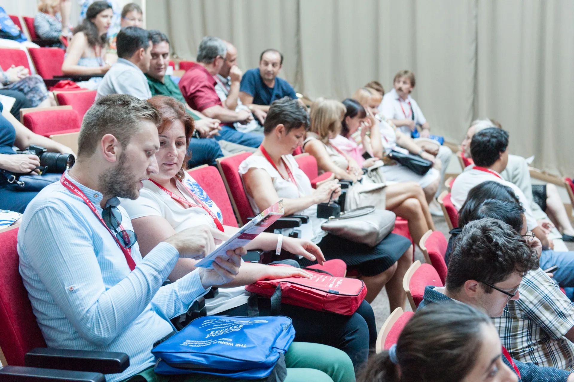 Delegates reviewing conference papers before a session