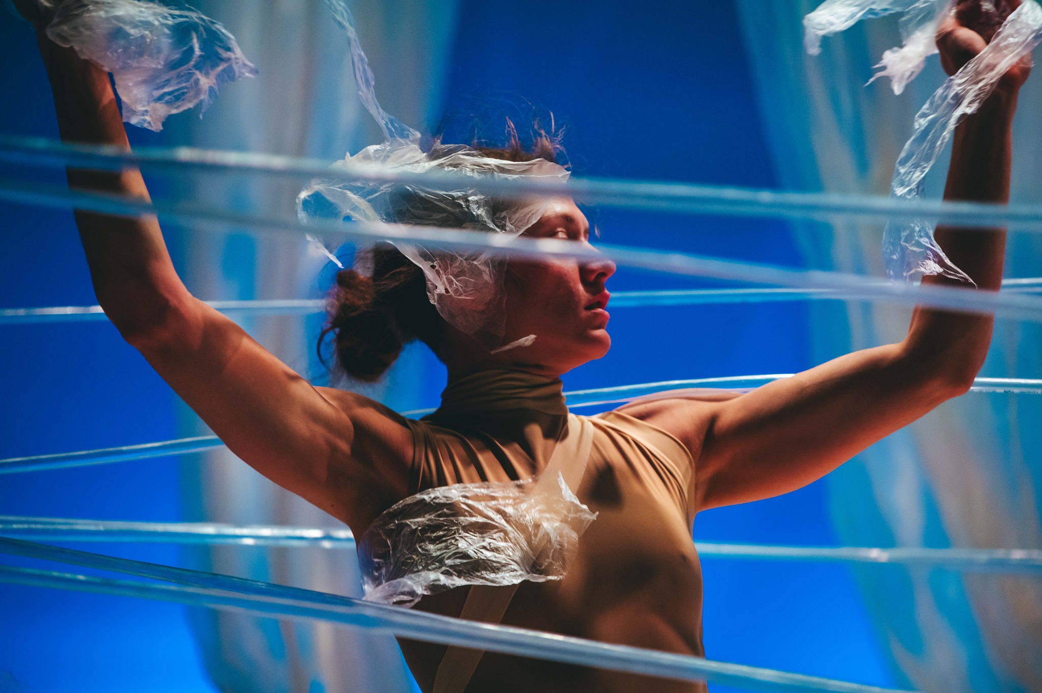 A stage performer surrounded by blue ribbons of light