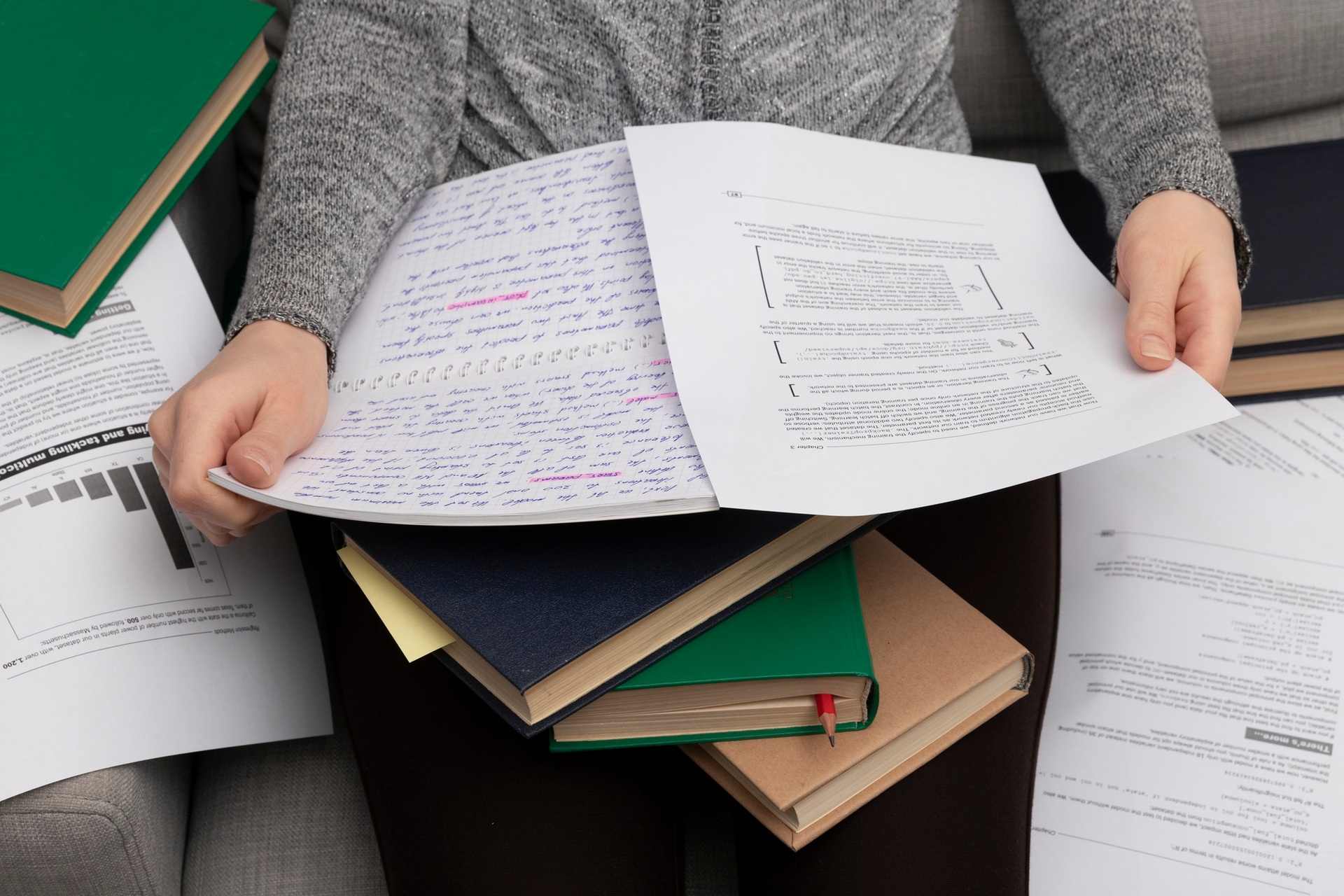 Un investigador leyendo artículos anotados sobre una pila de libros