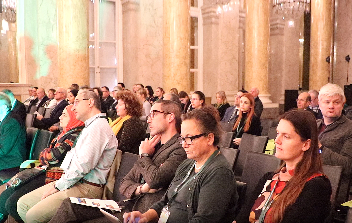 Conference audience seated in an ornate hall