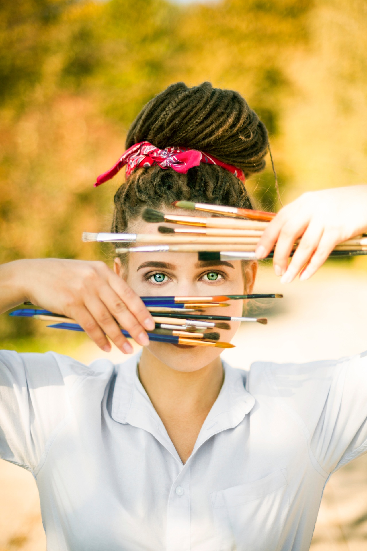 An artist looking through a row of paintbrushes