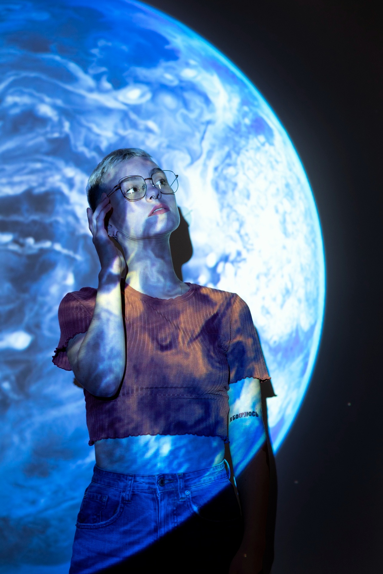 A visitor beside a large illuminated view of Earth