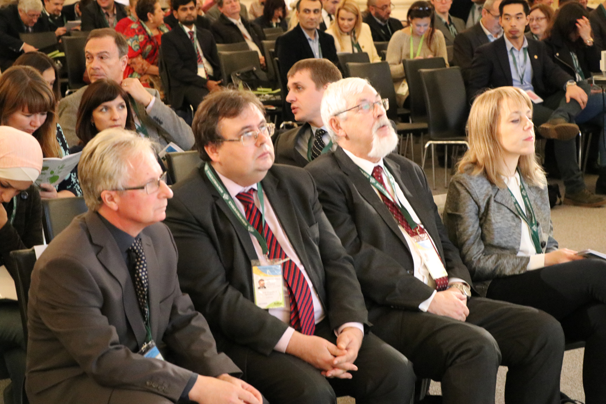 Conference delegates seated in the front rows of an auditorium