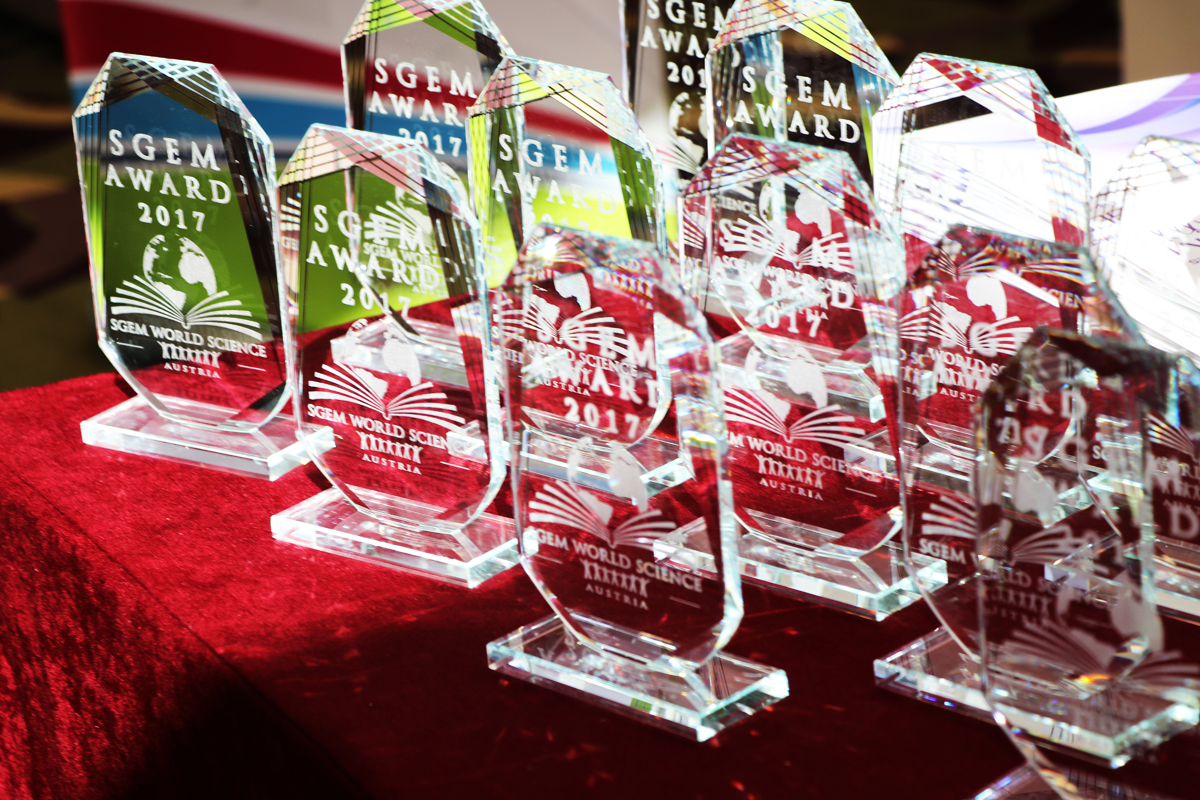 Glass SGEM awards displayed on a red table