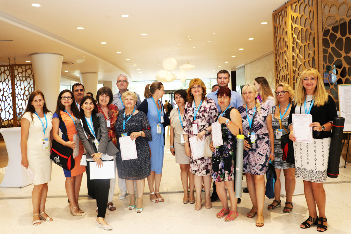 Conference participants posing together with certificates