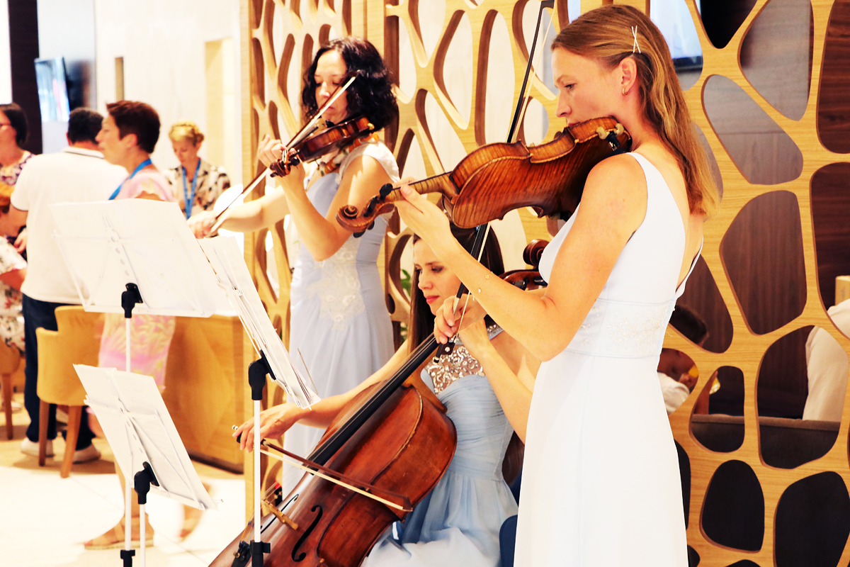 Violinists and a cellist performing at a conference reception