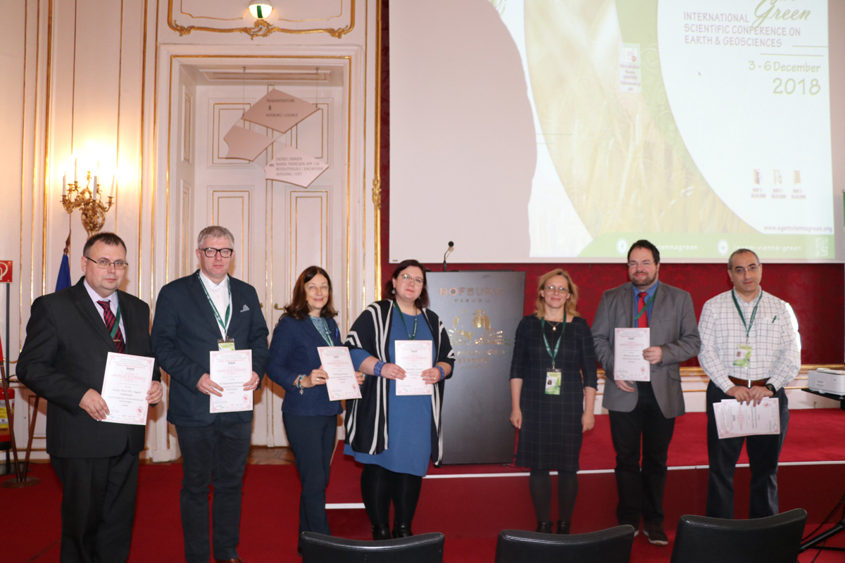 SGEM delegates displaying certificates beneath a presentation screen