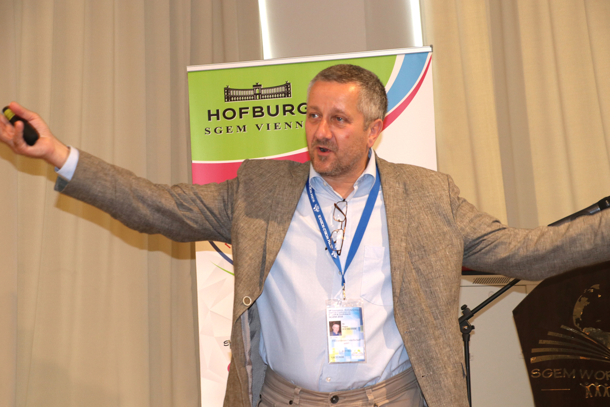 An SGEM speaker addressing the audience with outstretched arms