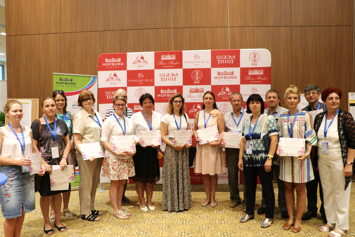 SGEM participants holding certificates in front of a conference backdrop