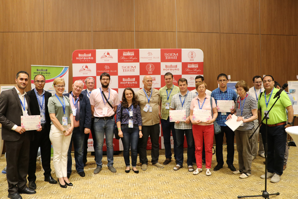 Conference delegates posing with certificates in front of SGEM banners