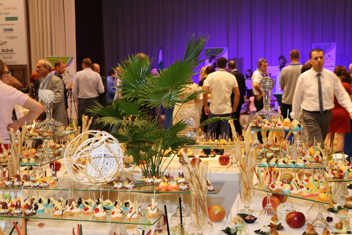 Guests mingling beside a decorated conference buffet