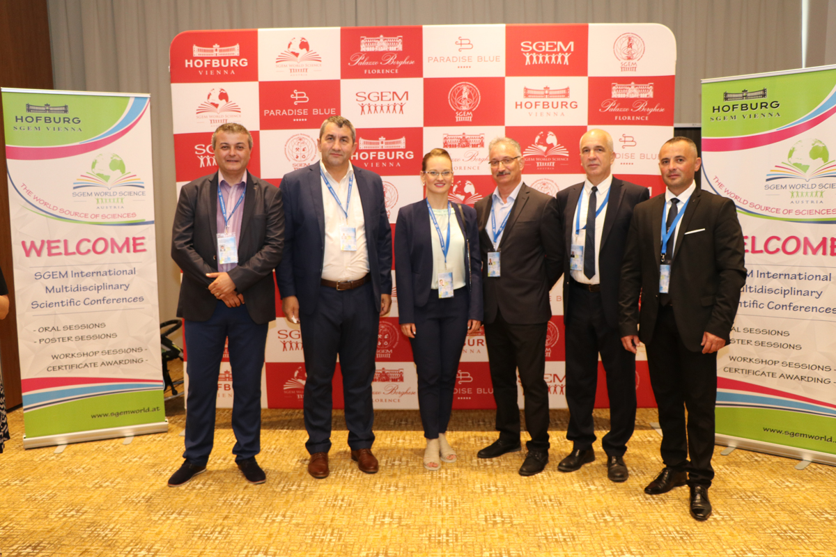 Six SGEM delegates posing in front of conference banners