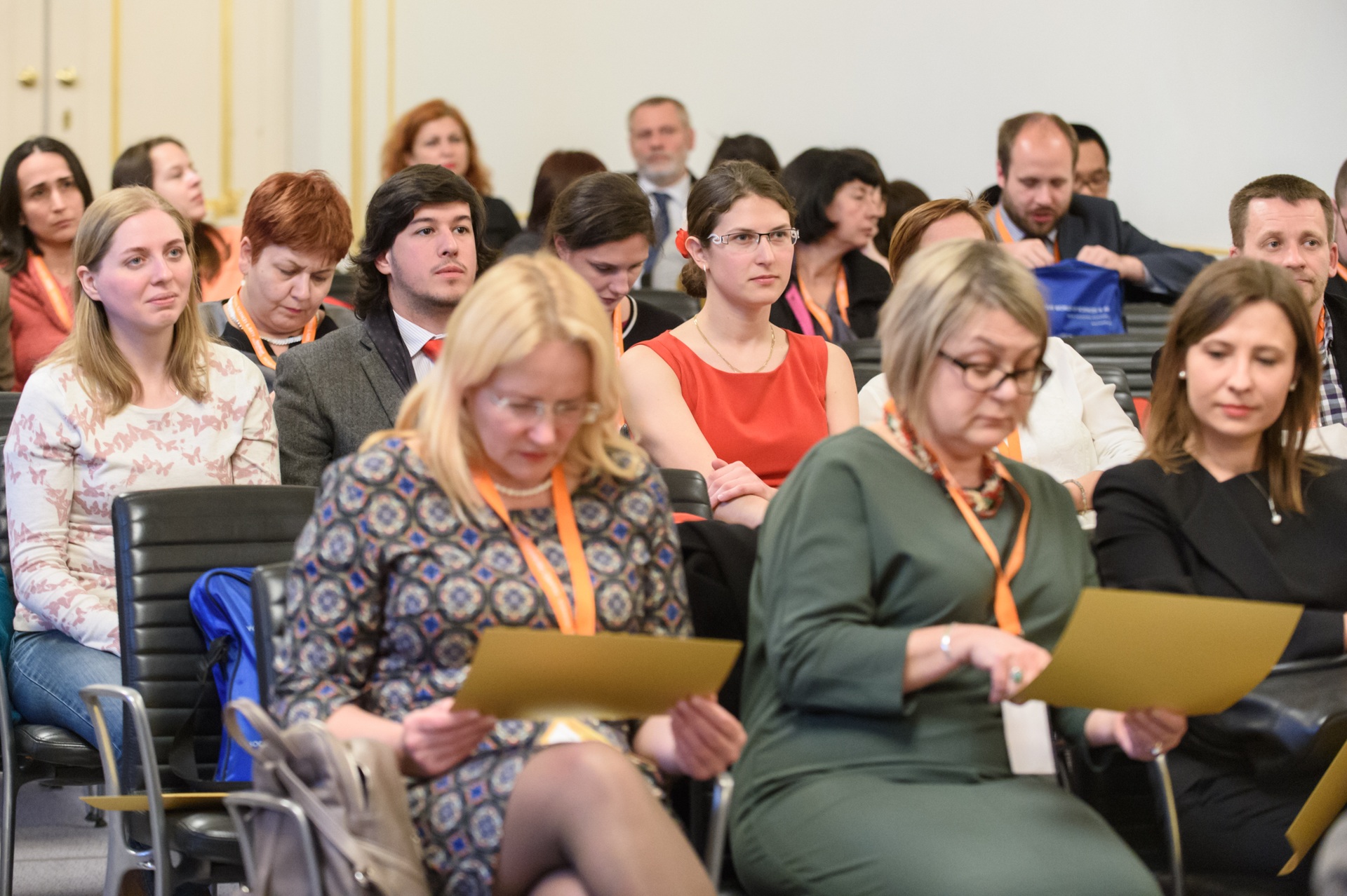 Delegates reading their programmes before a conference session