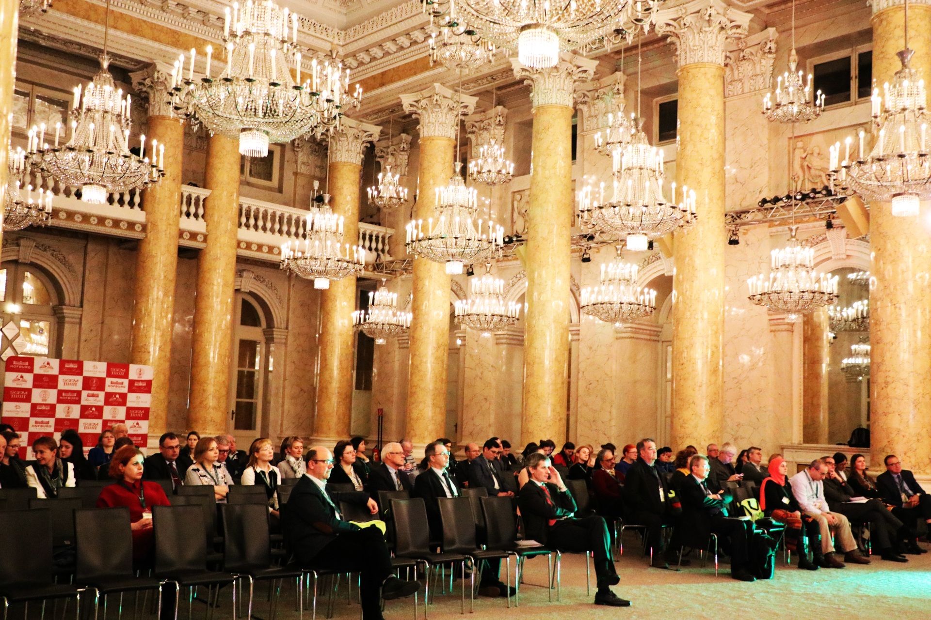 SGEM conference audience beneath large crystal chandeliers