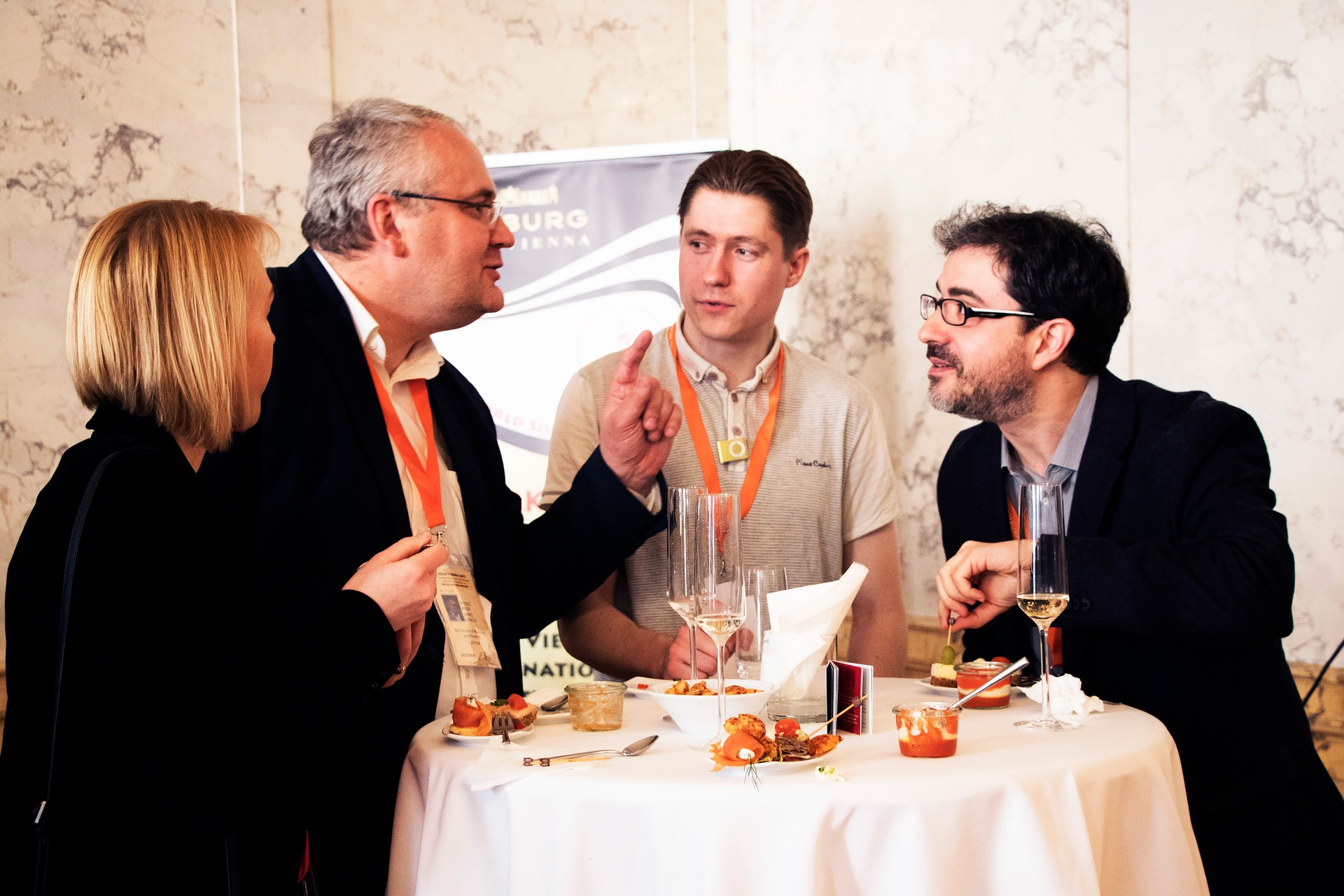 Four delegates exchanging ideas around a reception table