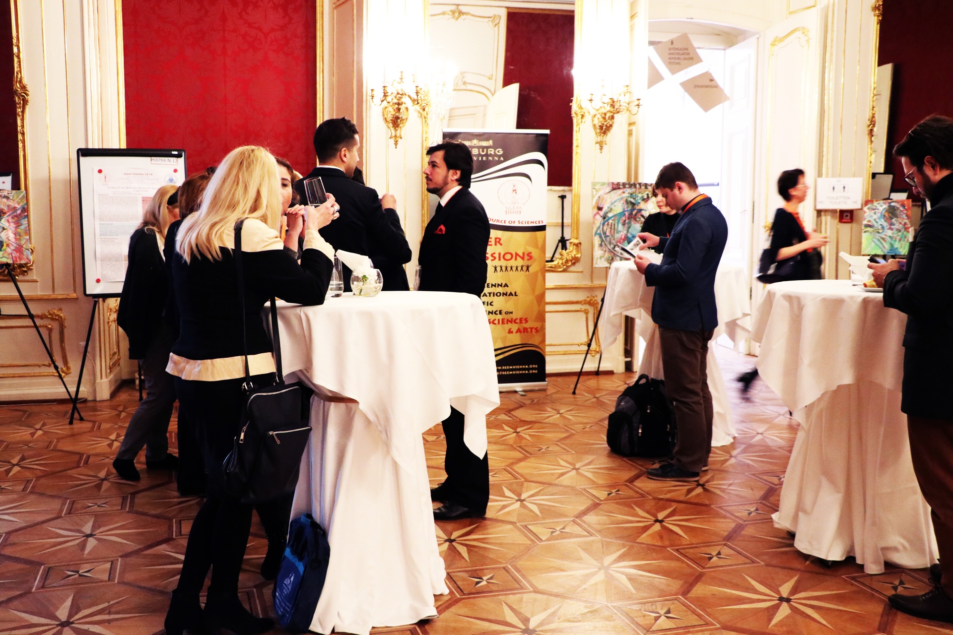 Delegates networking beside scientific posters at a reception