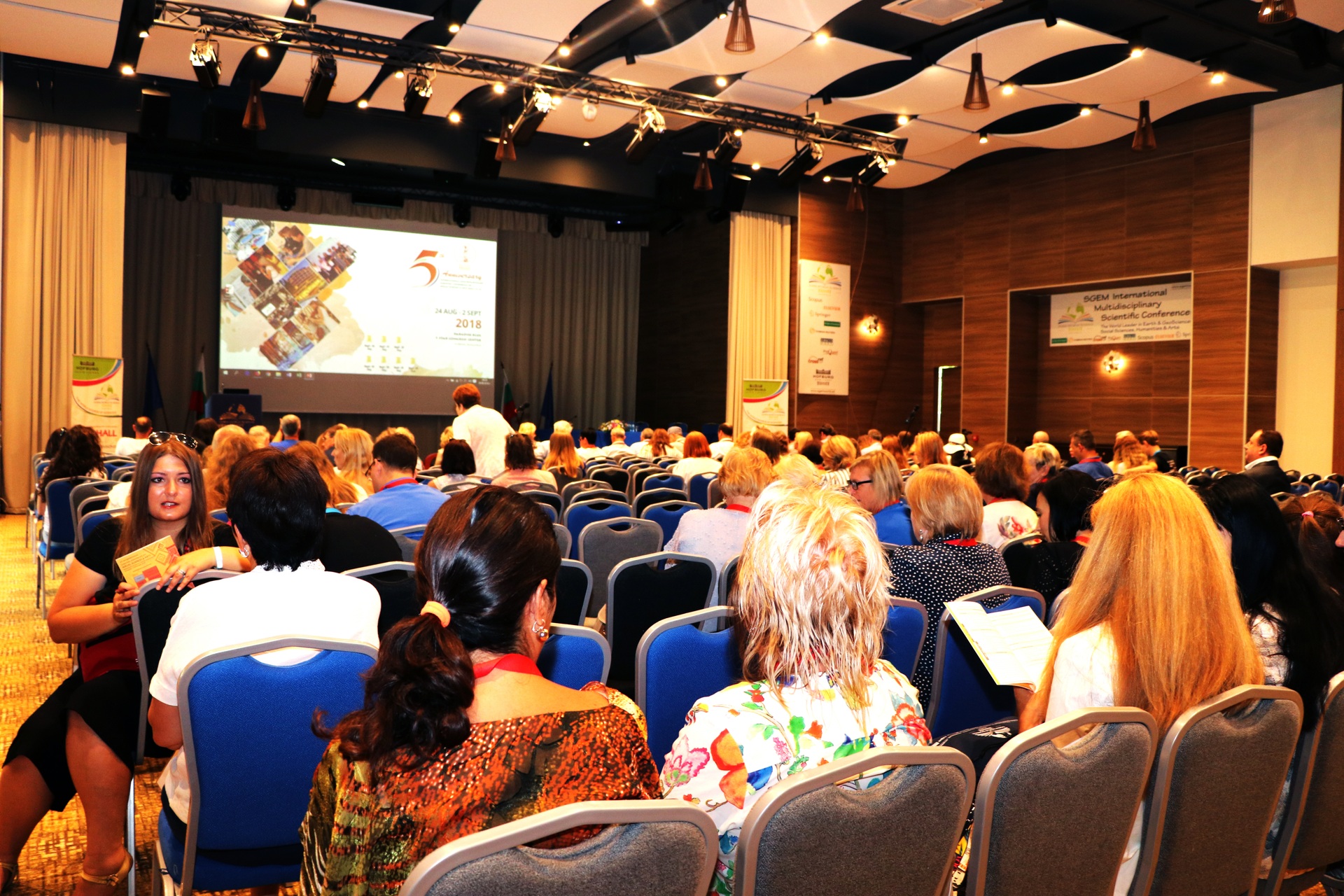 An SGEM audience watching a presentation on a large screen