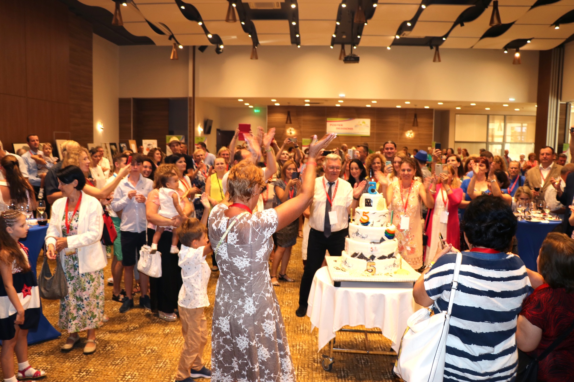 A conference gathering celebrating around a large cake