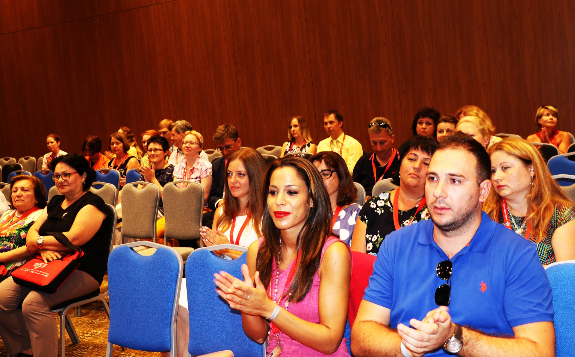 Two delegates applauding among an SGEM audience