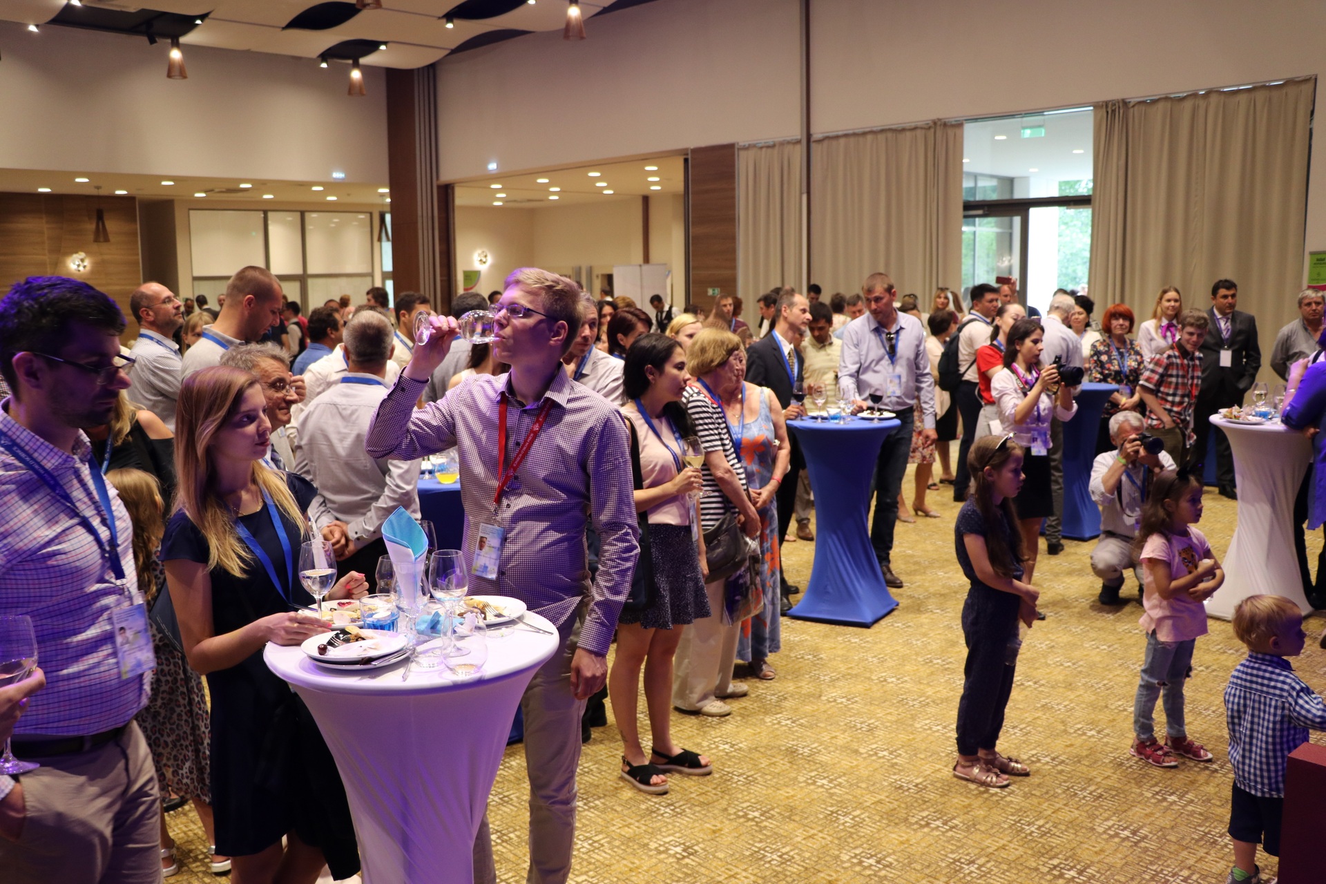 Delegates networking around standing tables at a conference reception
