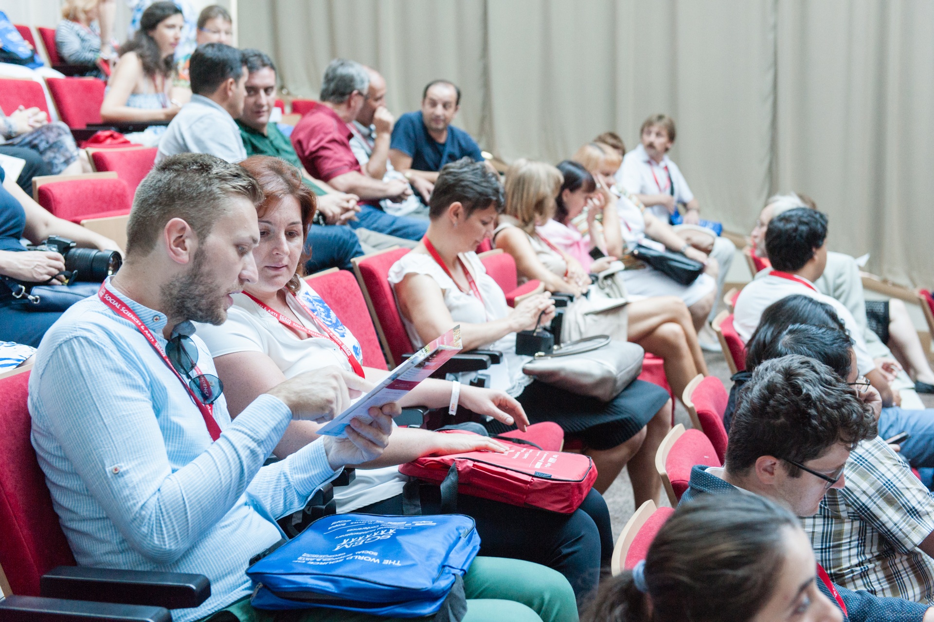 Delegates reviewing conference papers before a session