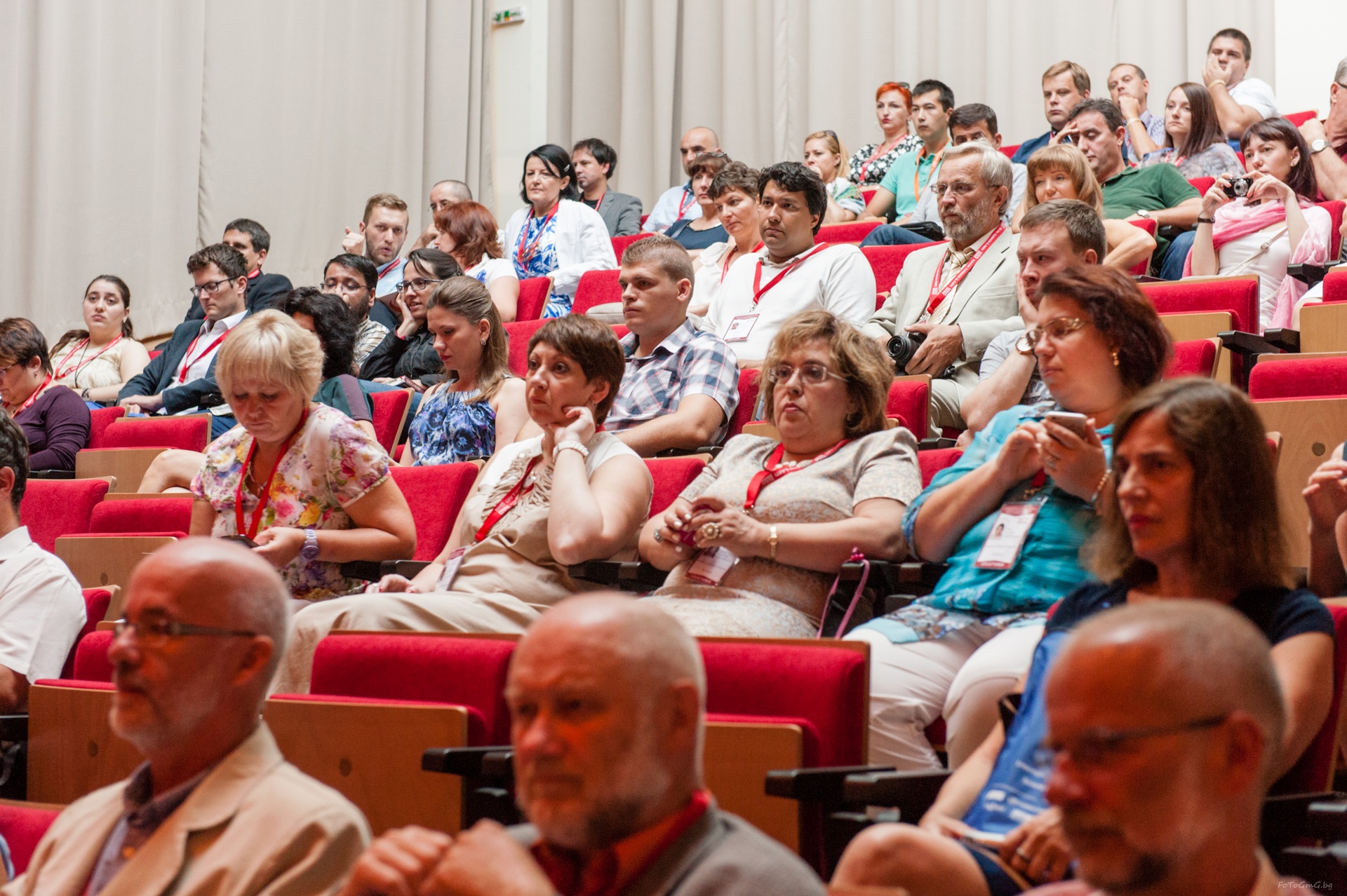 SGEM delegates listening from tiered rows of red seats