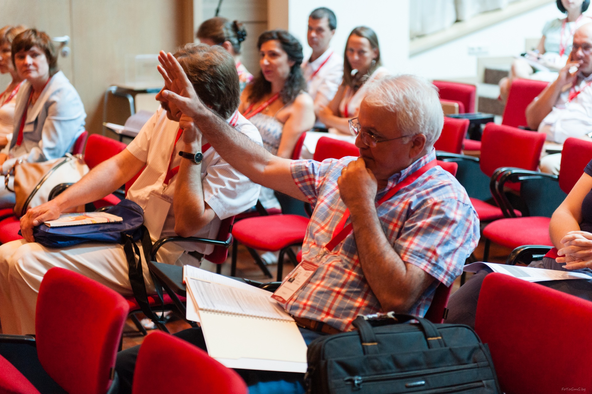 An audience member raising his hand during a conference discussion