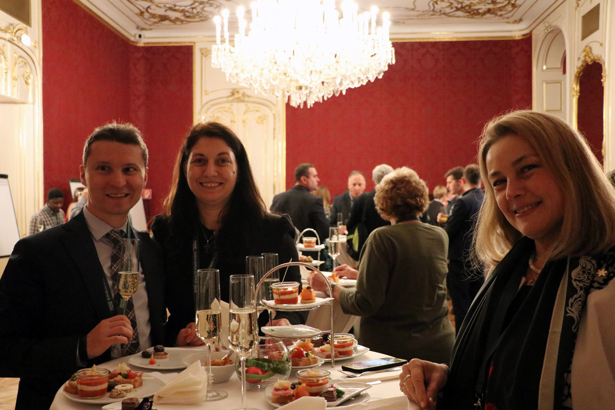 Three delegates seated at a conference dinner