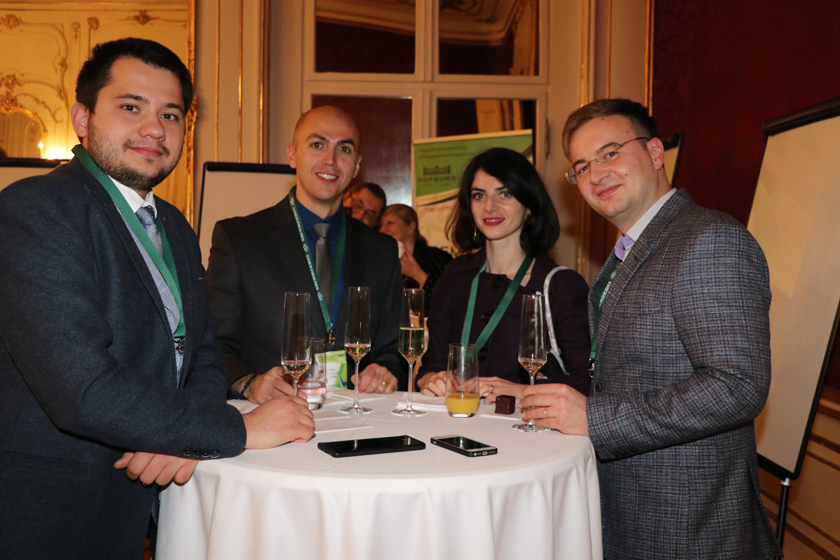 Four delegates talking around a conference reception table