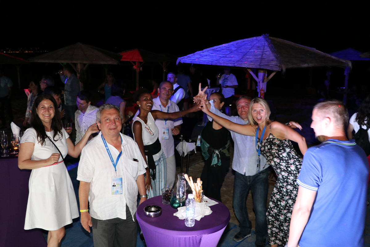 Delegates raising their arms during an outdoor evening reception