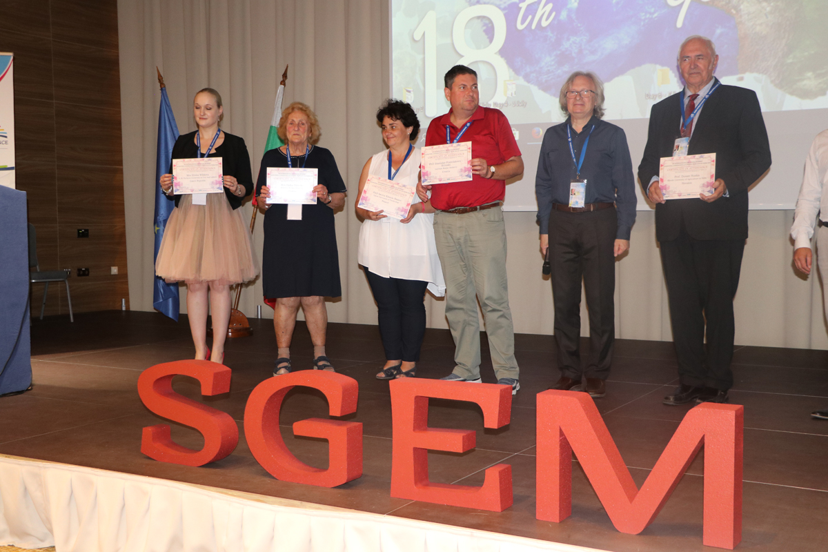 Certificate recipients on a stage behind large SGEM letters
