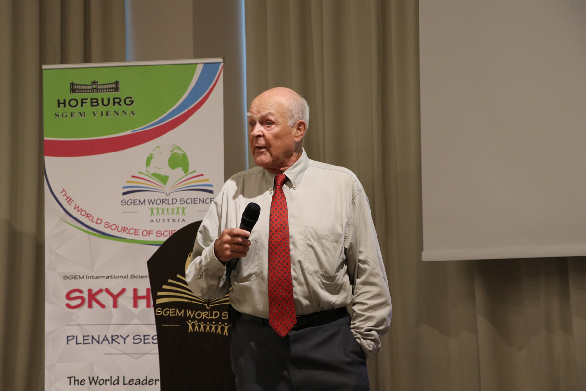 A scientist holding a microphone beside the SGEM lectern