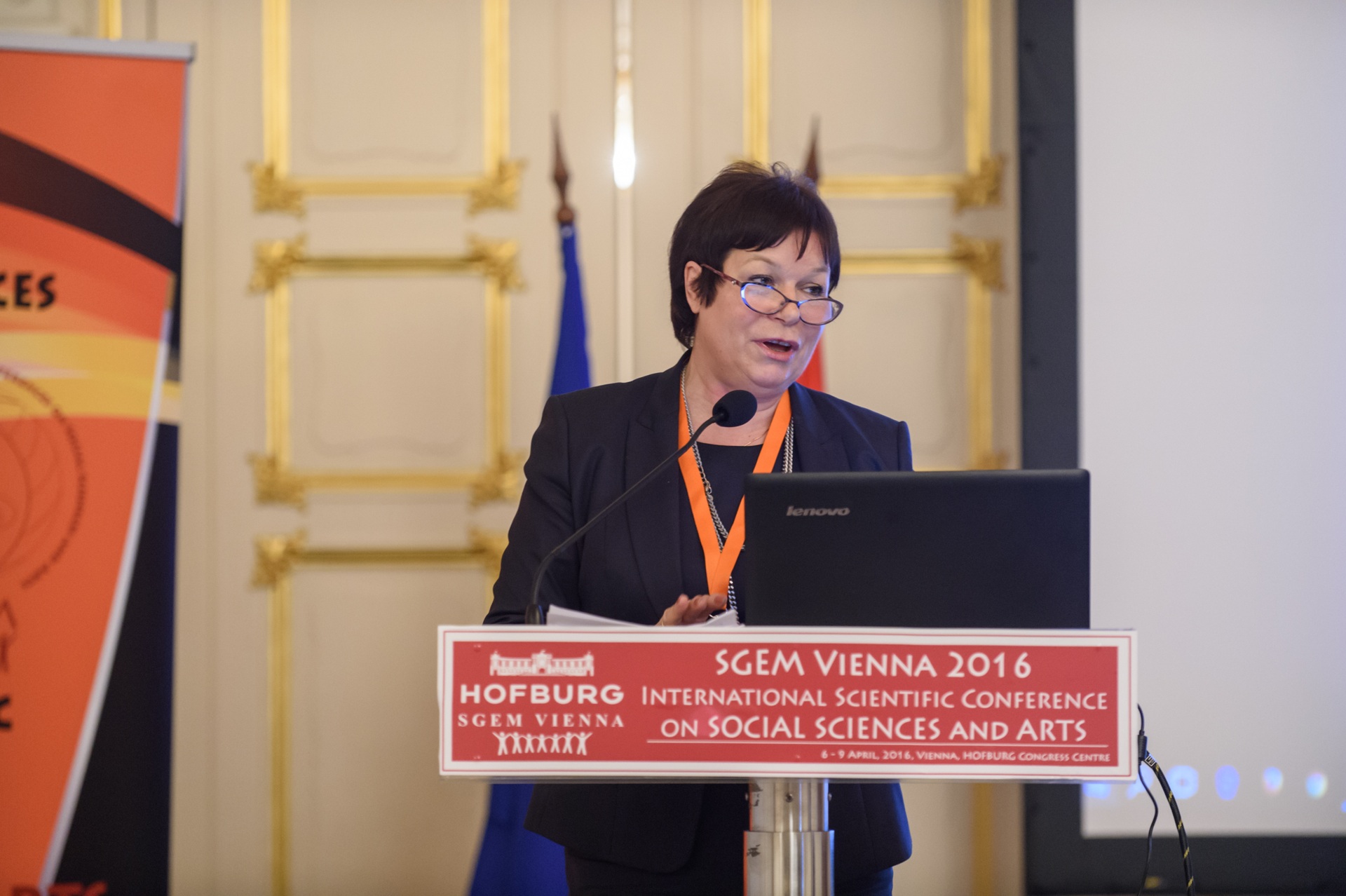 An SGEM Vienna presenter reading from a laptop at the lectern