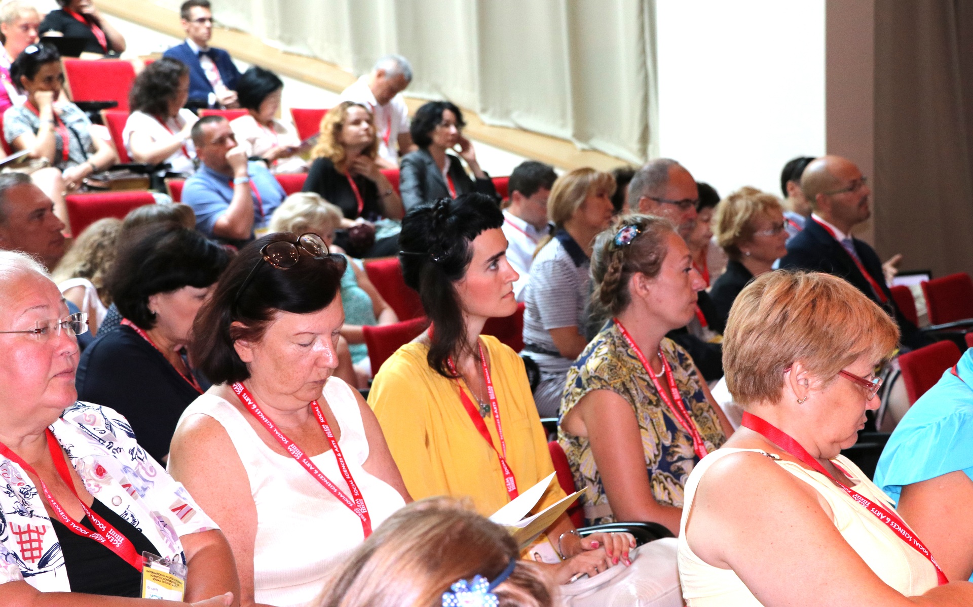 Delegates reading and taking notes in an auditorium