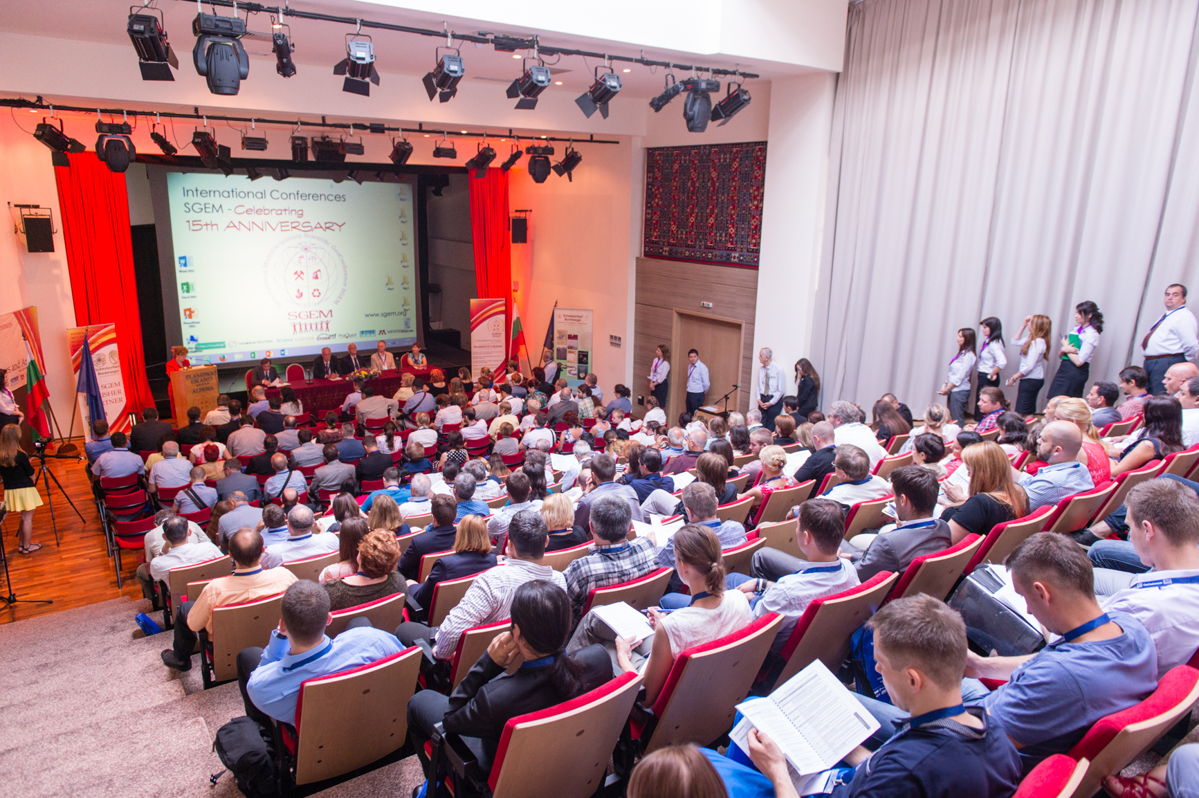 A full scientific conference auditorium viewed from the back