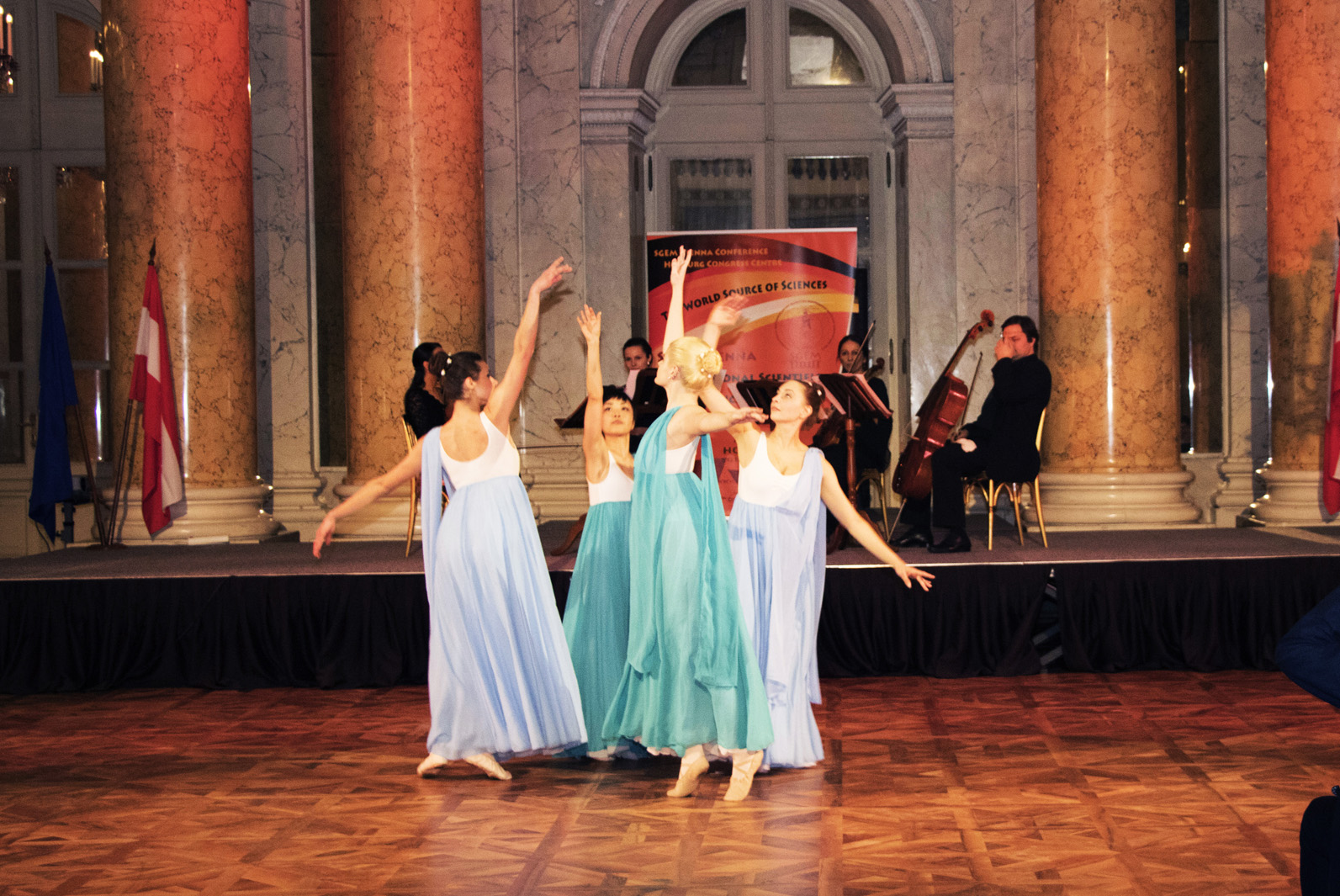 Dancers in flowing dresses performing before a chamber ensemble