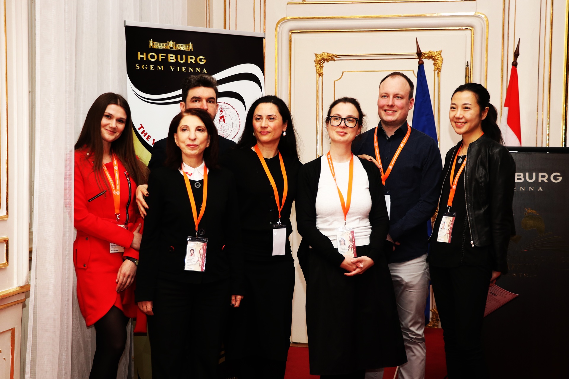 Seven delegates posing beside an SGEM Vienna conference banner